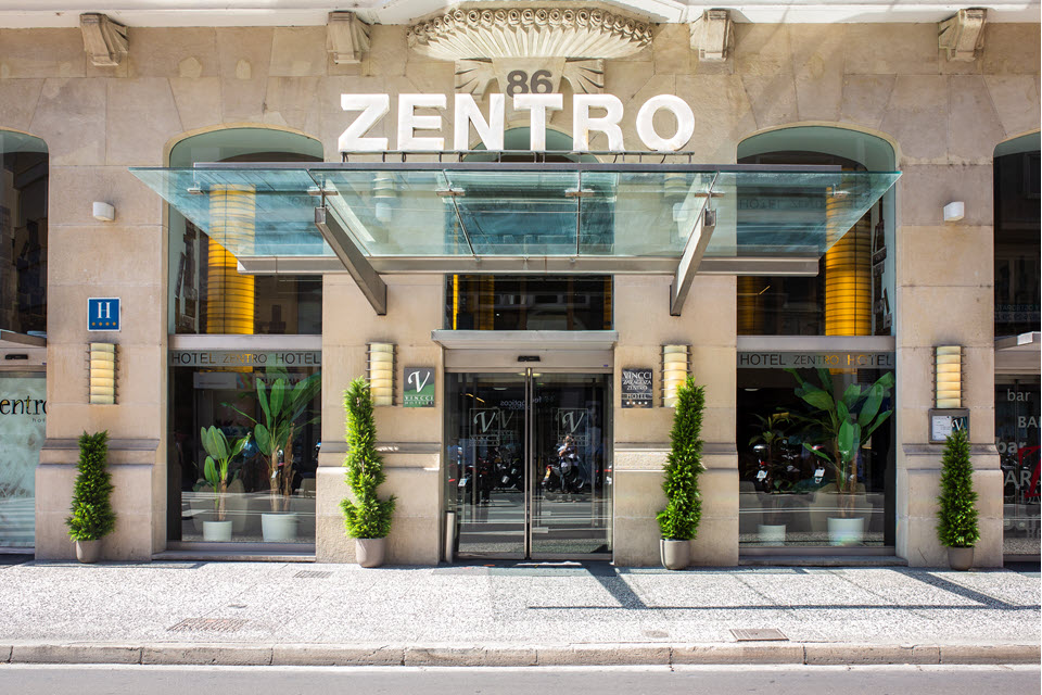 Entrada principal del Hotel Vincci Zaragoza con marquesina de cristal y fachada clásica restaurada.