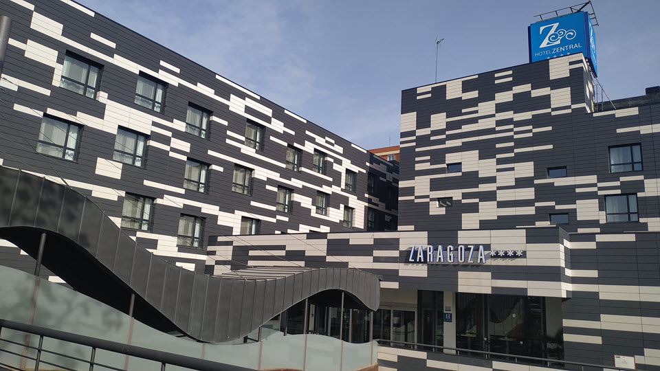Fachada moderna del Hotel Zentral AVE Zaragoza con diseño geométrico en tonos grises y blancos.